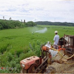 여름철 비가 갠후 병해충 방제를 위해 농업인들이 경운기를 이용하여 방제작업을 실시하고 있다.